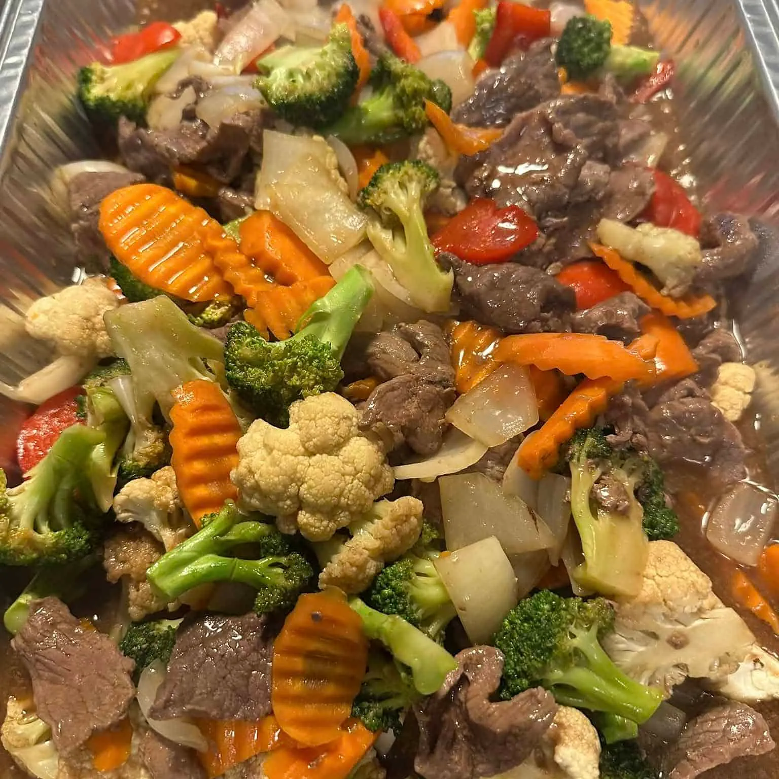 Biffwok med brokkoli, blomkål, gulrøtter, løk og paprika i saus.
