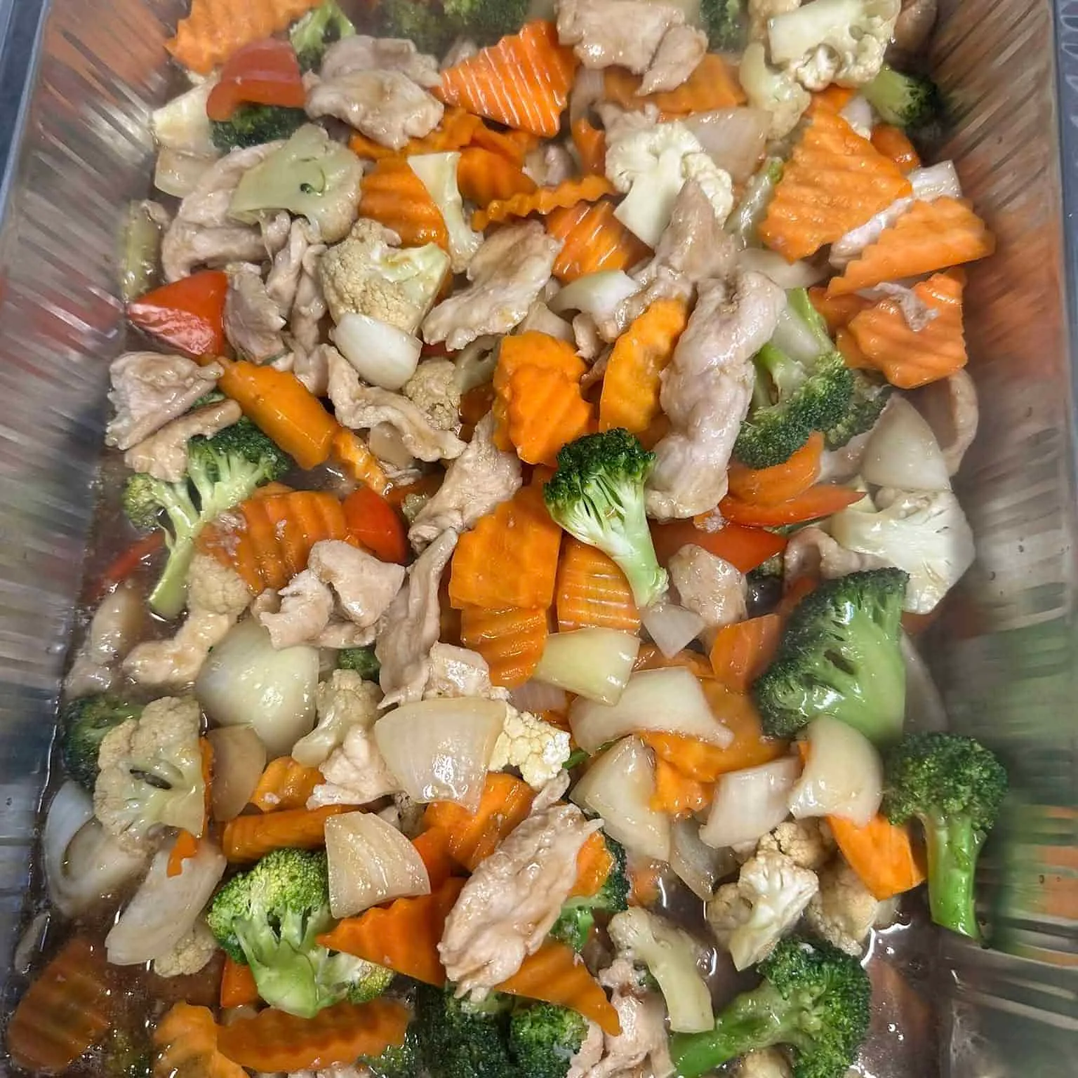 Wok med svinekjøtt, gulrøtter, brokkoli, blomkål og løk i soyabasert saus.